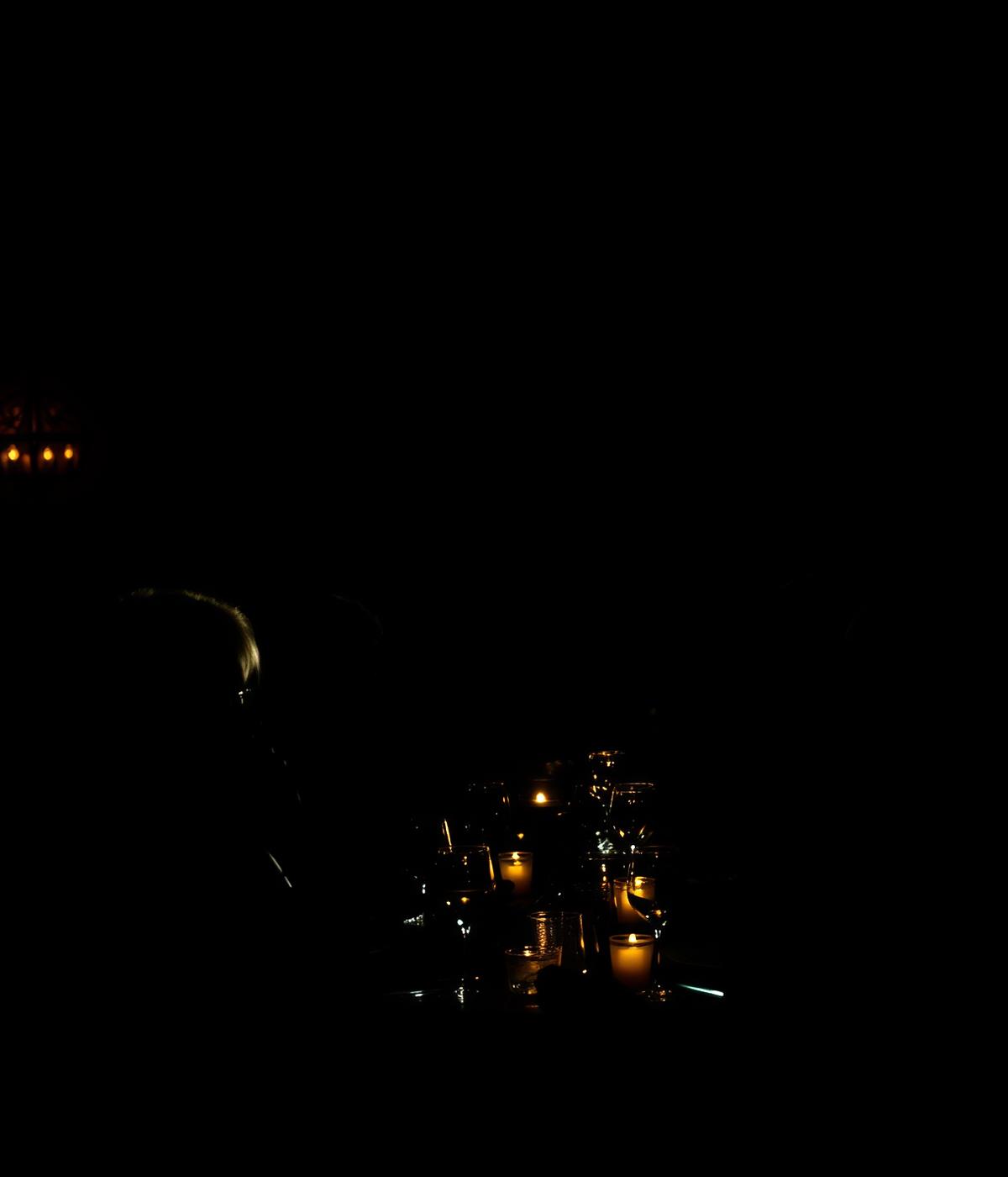 Dinner In The Dark Atmosphäre mit Gästen an einem Tisch in fast völliger Dunkelheit